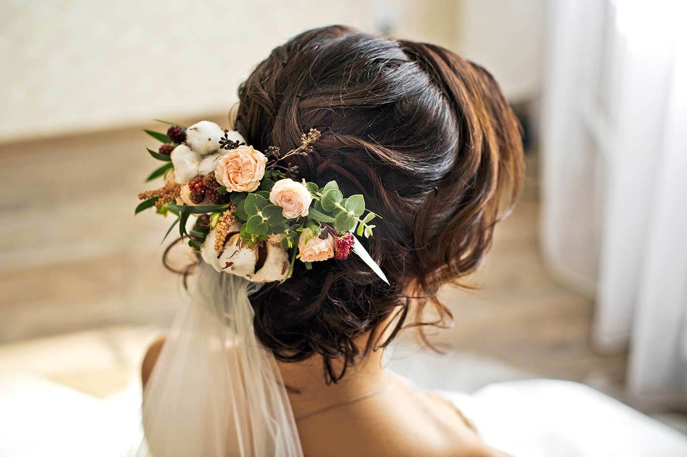 Brautfrisur mit Blumen und Schleier